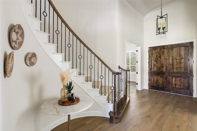 foyer entrance with high vaulted ceiling and dark hardwood / wood-style flooring