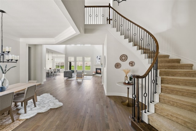 foyer entrance featuring a notable chandelier, crown molding, and hardwood / wood-style floors