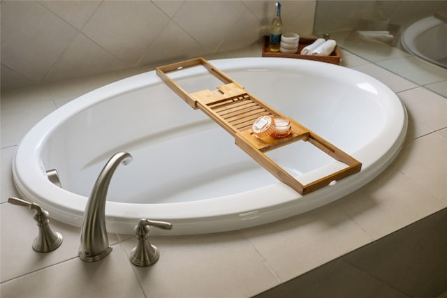 interior details with a tub and tile patterned floors