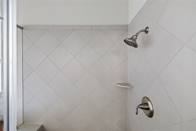 interior details featuring a tile shower