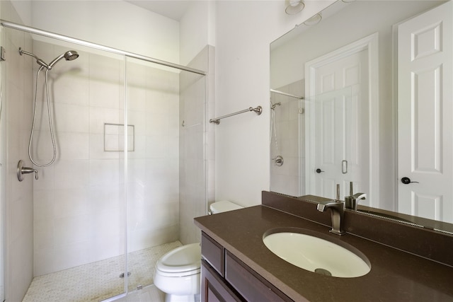 bathroom with a shower with shower door, toilet, and vanity