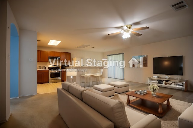 carpeted living room featuring ceiling fan