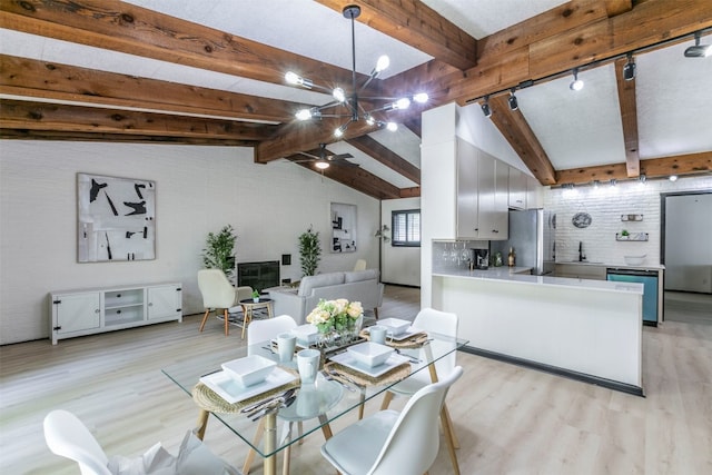 dining area featuring light wood-type flooring, lofted ceiling with beams, and sink