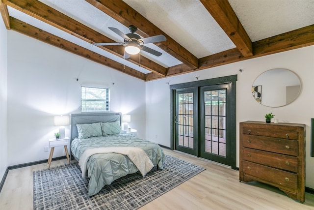 bedroom with ceiling fan, access to outside, beamed ceiling, a textured ceiling, and light hardwood / wood-style flooring