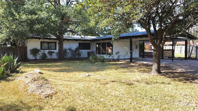 ranch-style home featuring a front lawn and a patio