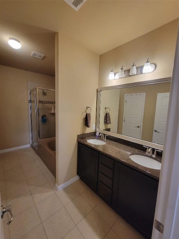 bathroom featuring vanity, tile patterned flooring, and shower / bath combination with glass door