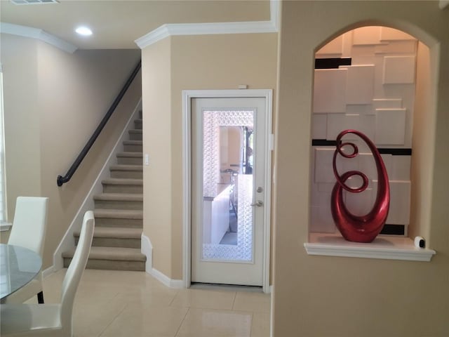 tiled entryway featuring crown molding