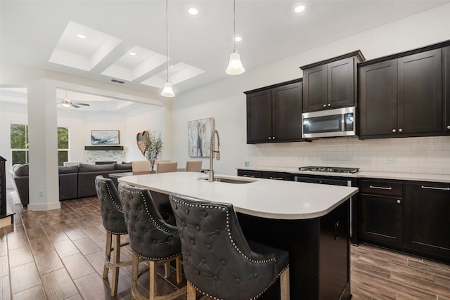 kitchen featuring a breakfast bar area, an island with sink, and appliances with stainless steel finishes