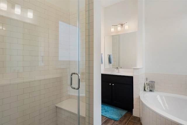 bathroom with plus walk in shower, hardwood / wood-style floors, and vanity