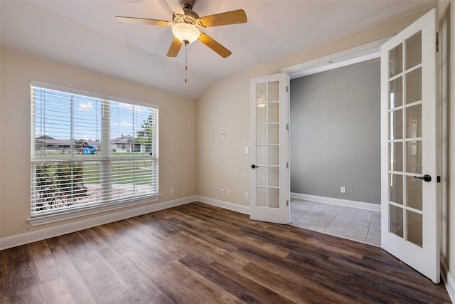 empty room with french doors, dark hardwood / wood-style floors, ceiling fan, and vaulted ceiling