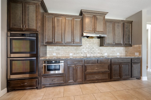 kitchen featuring decorative backsplash, double oven, and light tile patterned floors