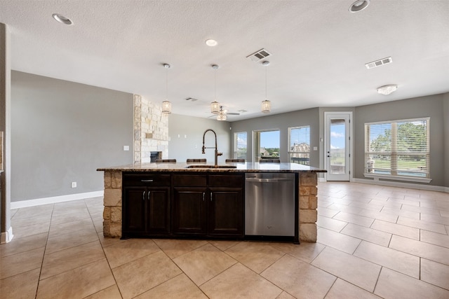 kitchen with a wealth of natural light, sink, dishwasher, and an island with sink