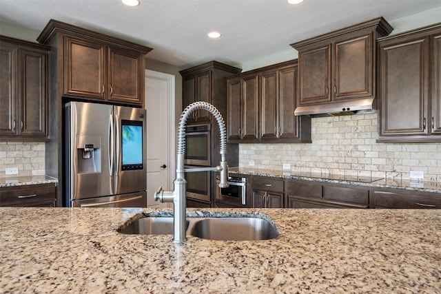 kitchen featuring decorative backsplash, black electric cooktop, stainless steel fridge with ice dispenser, dark brown cabinetry, and light stone counters