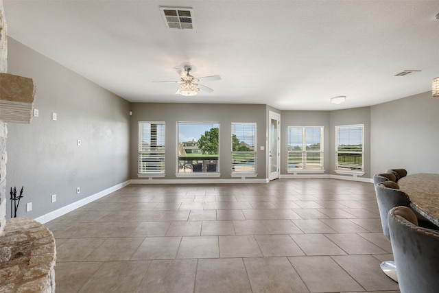 tiled living room featuring ceiling fan and a wealth of natural light