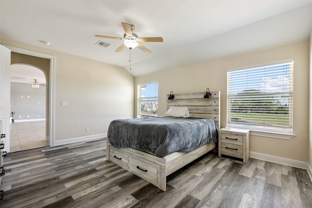 bedroom featuring dark wood-type flooring, ceiling fan, and multiple windows