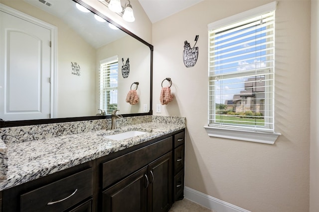 bathroom with vanity and lofted ceiling