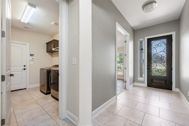 tiled foyer featuring washing machine and dryer