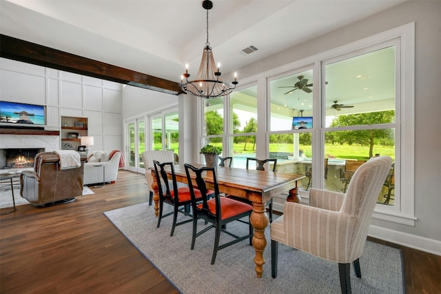 dining room with a fireplace, ceiling fan with notable chandelier, and hardwood / wood-style floors