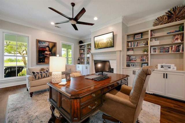 home office featuring ceiling fan, dark wood-type flooring, built in features, and ornamental molding