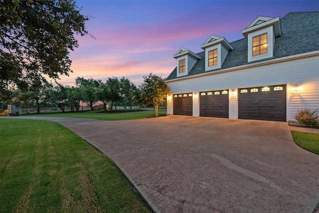 property exterior at dusk featuring a garage and a yard