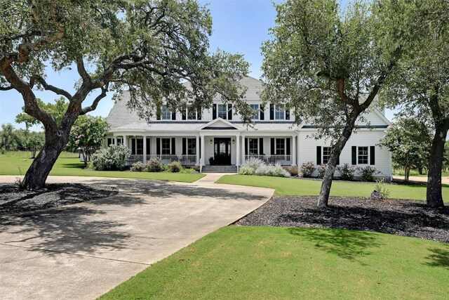 view of front of property featuring covered porch and a front lawn