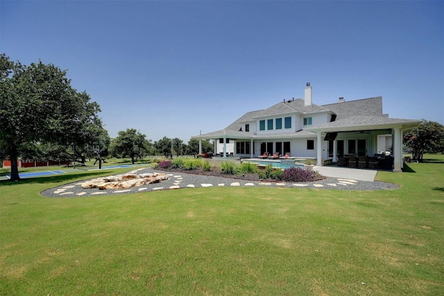 back of house featuring a patio area and a lawn