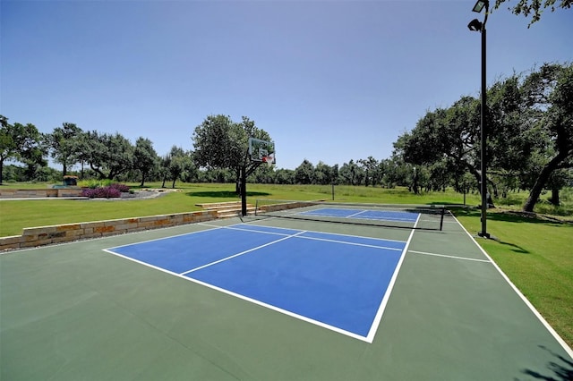 view of sport court featuring a lawn and basketball court