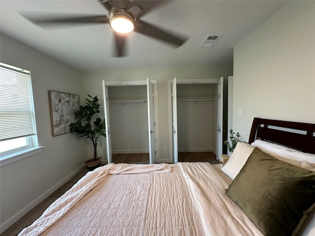 unfurnished bedroom with two closets and ceiling fan