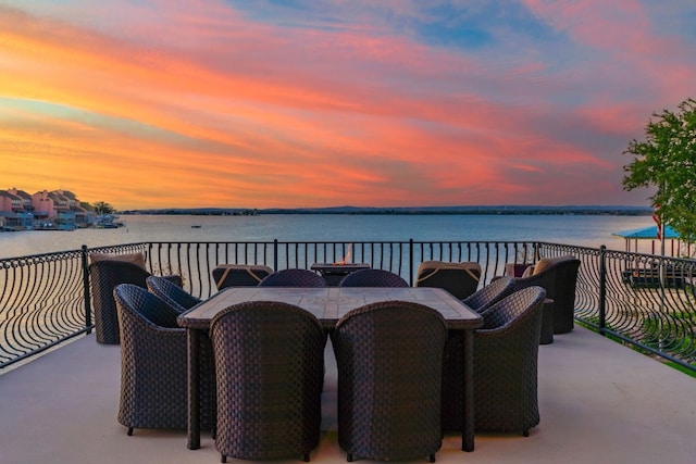 patio terrace at dusk with a balcony and a water view