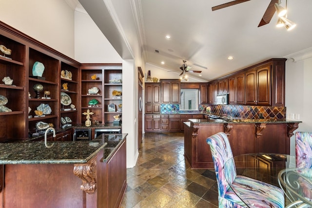 kitchen with dark tile patterned floors, dark stone countertops, ceiling fan, decorative backsplash, and vaulted ceiling