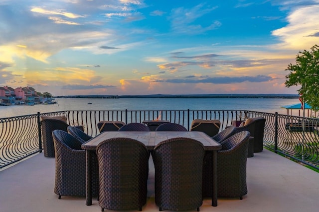 patio terrace at dusk with a balcony and a water view