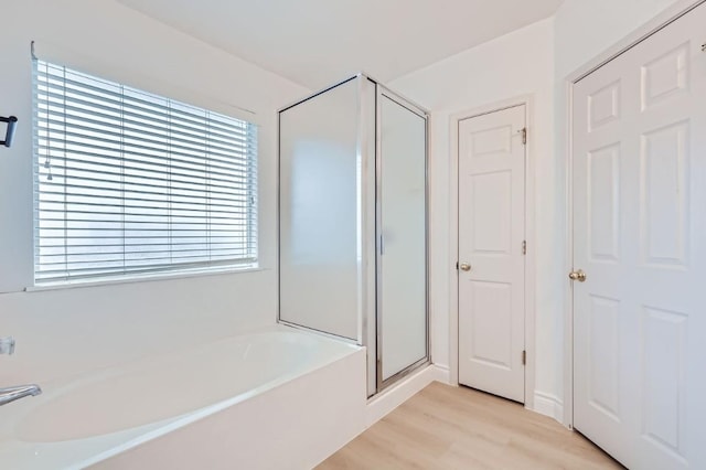 bathroom featuring hardwood / wood-style floors and shower with separate bathtub