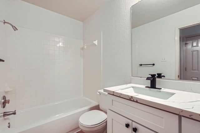 full bathroom with vanity, tiled shower / bath combo, and toilet