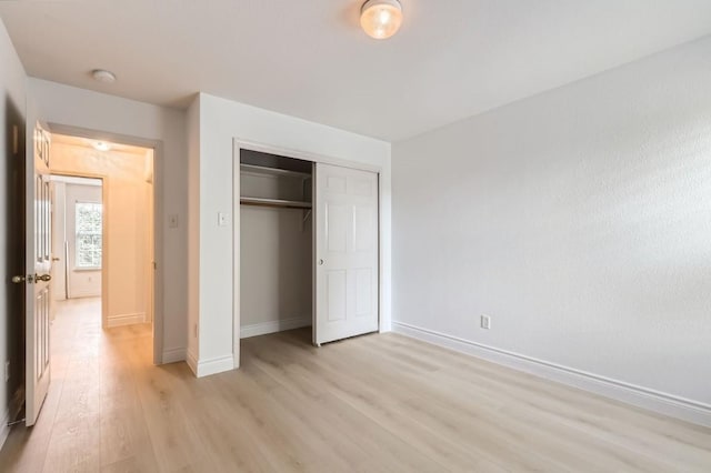 unfurnished bedroom featuring light hardwood / wood-style floors and a closet