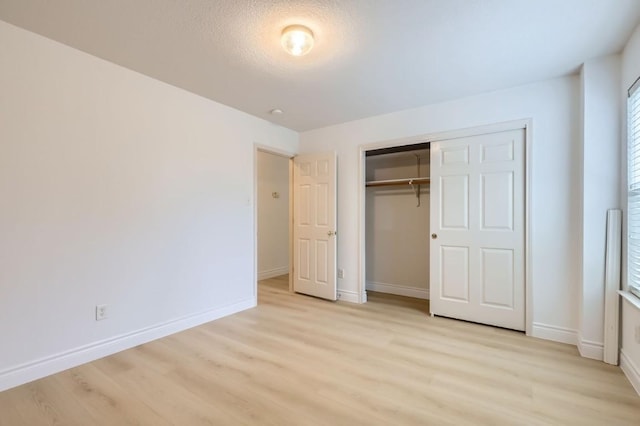 unfurnished bedroom featuring a closet, light hardwood / wood-style flooring, and a textured ceiling