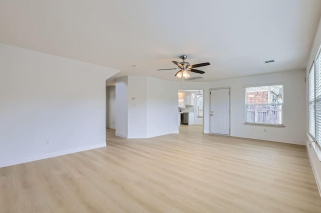 unfurnished living room with ceiling fan with notable chandelier and light wood-type flooring