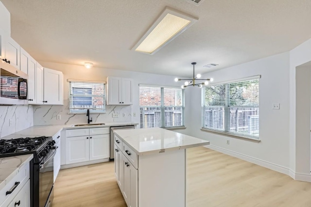 kitchen featuring white cabinetry, appliances with stainless steel finishes, a center island, and sink