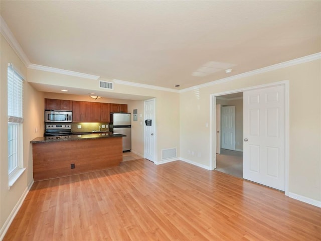 kitchen with a peninsula, visible vents, appliances with stainless steel finishes, light wood-type flooring, and dark countertops