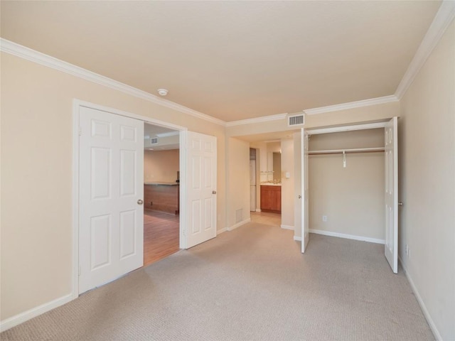 unfurnished bedroom featuring baseboards, visible vents, ornamental molding, and light colored carpet