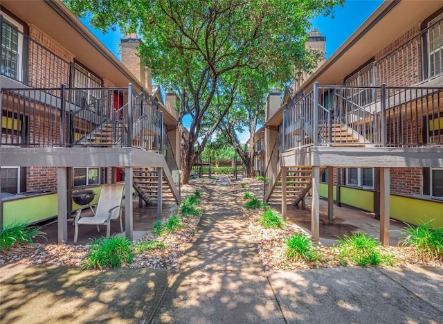 view of home's community featuring stairs and a patio