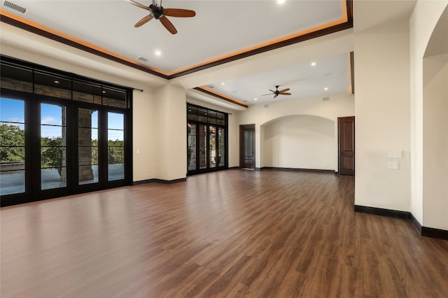 empty room featuring ceiling fan, dark hardwood / wood-style floors, and a raised ceiling