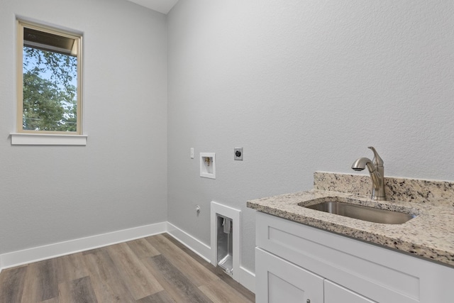 clothes washing area with sink, light hardwood / wood-style flooring, hookup for a washing machine, electric dryer hookup, and hookup for a gas dryer