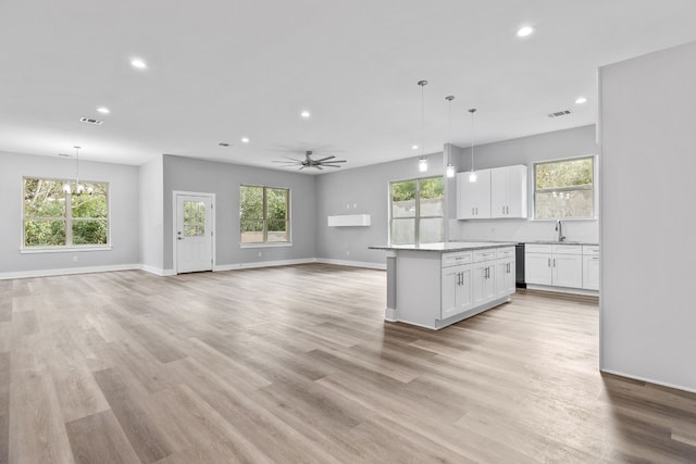 kitchen featuring white cabinetry, hanging light fixtures, and a wealth of natural light