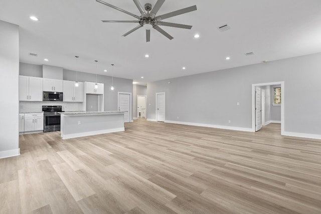 unfurnished living room featuring ceiling fan and light hardwood / wood-style floors