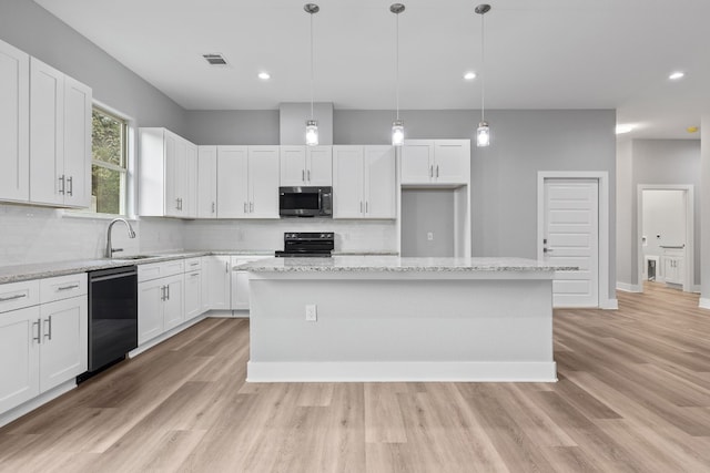 kitchen with range with electric cooktop, a kitchen island, decorative light fixtures, black dishwasher, and white cabinets