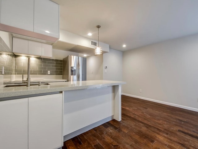 kitchen featuring decorative light fixtures, white cabinetry, sink, backsplash, and stainless steel fridge with ice dispenser