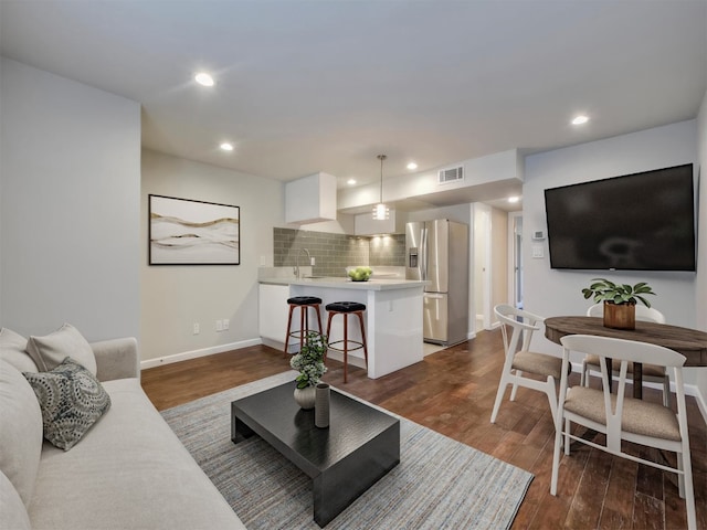 living room featuring dark hardwood / wood-style floors and sink