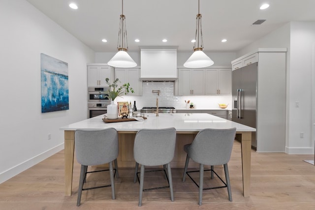 kitchen featuring stainless steel appliances, premium range hood, a large island, and pendant lighting