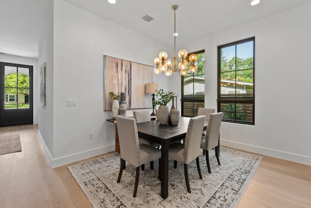 dining space featuring a chandelier and light wood-type flooring