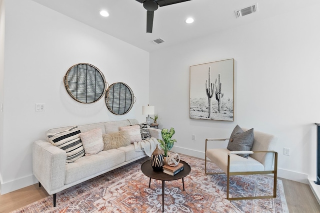 living room with wood-type flooring and ceiling fan